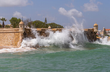 Fortress of Ponta da Bandeira gets hit by a huge wave in Lagos, Algarve, Portugal