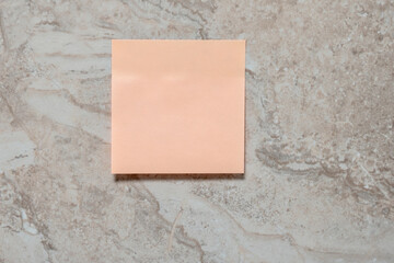 Empty paper sticker on marbled tile wall. Space for your text.