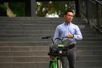 Shot of millennial businessman pushing bike on the street city. Business and city life concept - 796364913