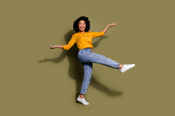 Full size photo of nice young woman dancing wear yellow shirt isolated on khaki color background