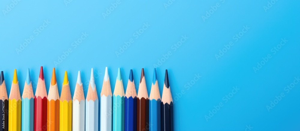 Poster colored pencils array on blue backdrop