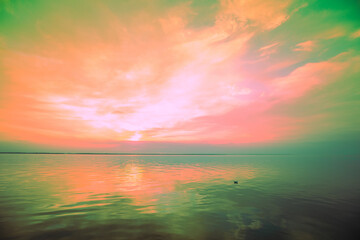 Seascape in the early morning. Calm sea at dawn with beautiful sky. Artistic pink green gradient...