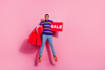 Full length photo of funny excited guy dressed striped pullover holding bargains gift box sale card...