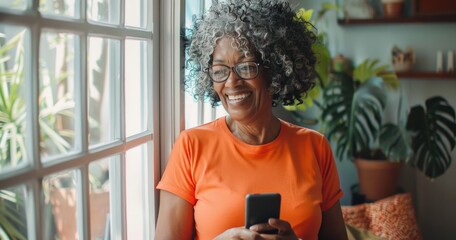 A happy mature female with curly hair smiling while using a mobile phone.