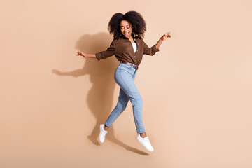 Fototapeta na wymiar Full length photo of satisfied gorgeous girl wear brown blouse jeans flying dancing look down on legs isolated on pastel color background