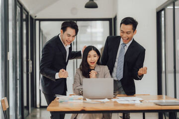 Young motivated Asian business team discussing oh business strategy in the modern meeting room.