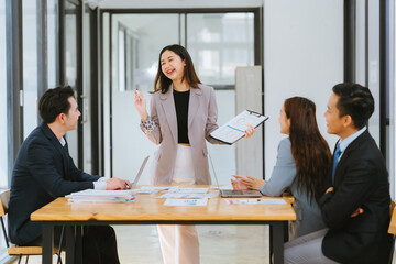 Meeting of Asian business people who are committed to work. Creative business teams work together in the office, discussing issues that need to be resolved, and