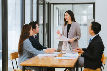 Meeting of Asian business people who are committed to work. Creative business teams work together in the office, discussing issues that need to be resolved, and