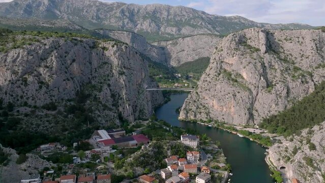 Amazing panoramic video of the picturesque town of Omish in Croatia, the cliffs, the old houses with red roofs, the historic buildings and the river flowing into the turquoise Adriatic Sea