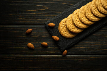Round cookies on a black serving board and almonds prepared for dessert at the hotel. Sweet snack...