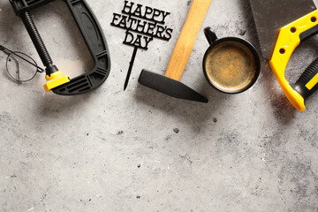 Happy Fathers Day background. Flat lay composition with carpentry tools and coffee cup on stone table.