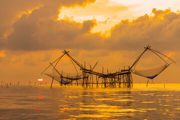 Sunrise and silhouette image of giant fishing net in the morning at Pakpra, Phatthalung, Thailand.