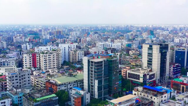 A wide shot of the cityscape of Bangladesh, showcasing its vibrant urban life with tall buildings and bustling streets under clear blue skies.