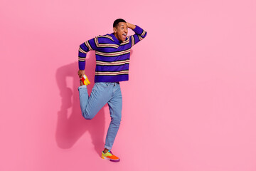 Full length photo of funky impressed man wear striped sweater having fun dancing empty space...