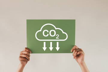 Hand showing green paper with Reduce CO2 icon on white background concept for  Eco-friendly...