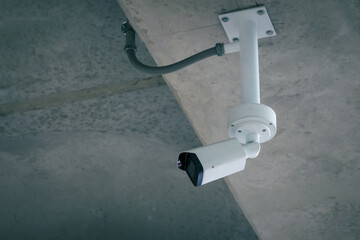 CCTV, indoor security camera on ceiling of modern building to monitor and record things happen for...