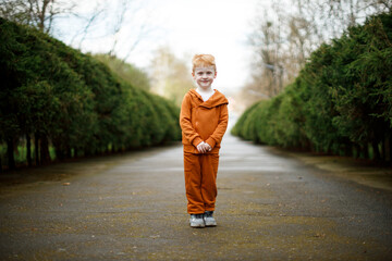 A 5-year-old Ukrainian boy walks in a park in a suit