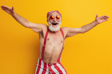 cool funky elderly guy dressed striped red swimsuit dancing having fun isolated yellow color background - Powered by Adobe