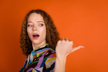 Photo of shocked impressed pretty girl wear trendy print clothes demonstrate empty space isolated...