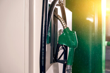 Green fuel nozzle hanging on the fuel dispenser
