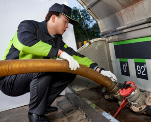 Asian male worker is filling oil at the gas station