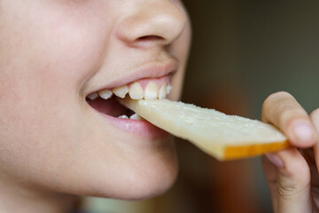 Happy anonymous teenage girl eating fresh cheese slice