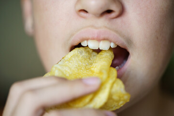 Crop unrecognizable girl eating crunchy potato chips - 796507506