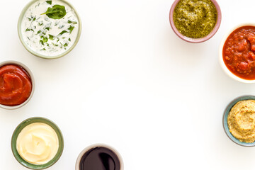 Set of sauces in bowls - pesto salsa mustard and others. Food background