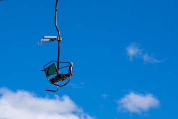 observation chair on a flat lift high in the sky. leisure.ski boots close up on the slope