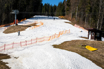 ski slope with skiers on a sunny day. View from above. Active leisure, school holidays