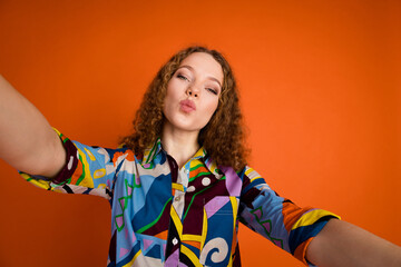 Photo of lovely adorable girl wear trendy print clothes send kiss blog vlog isolated on vibrant orange color background