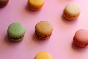 Colorful macarons on pink background. Selective focus.