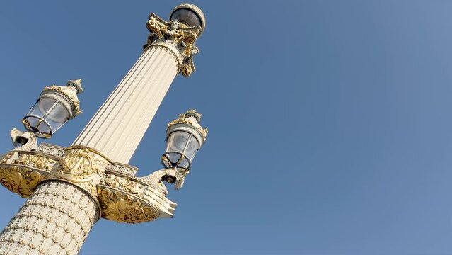 Bottom view footage of an old, traditional street light with blue sky background in Paris. It is a sunny summer day.