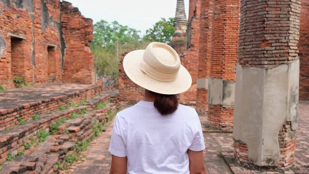 Asian tourists walk to see Thai temples in Ayutthaya. Thai architecture, ancient sites in national parks