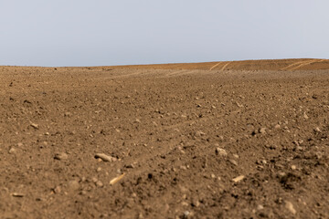 an agricultural field with plowed soil during spring sowing