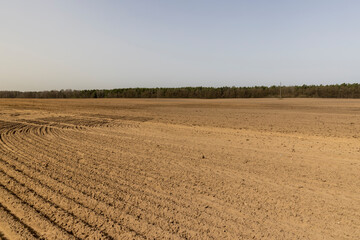 an agricultural field with plowed soil during spring sowing