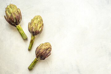 Food pattern with raw artichoke flower buds, top view
