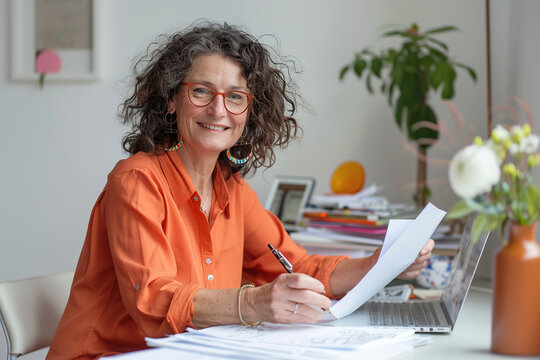 Mature successful financier accountant on paper work, documents contracts. Businesswoman boss smiling happy with achievement results. Financial advisor, lawyer or attorney at desk using laptop.