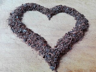 Heart shaped cracked broken chocolate chips chunks parts. Dark love shavings and slices border. Top...