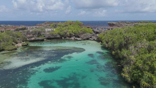 Weekuri Lagoon, Sumba island, Indonesia. A beautiful blue lake with a green forest in the background. The water is calm and clear, and the trees are lush and green