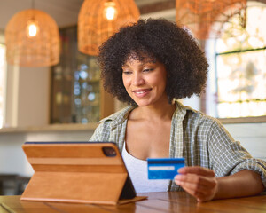 Excited Woman At Home With Digital Tablet And Credit Card Booking Holiday Or Shopping Online