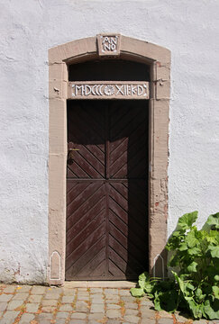 Wooden door in a neoclassical portal with date in roman numerals on a house in Kronenburg, Eifel region in Germany