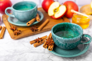 Fragrant hot tea with cinnamon stick and anise on a textured wooden background. A cup of hot tea...