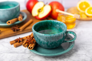 Fragrant hot tea with cinnamon stick and anise on a textured wooden background. A cup of hot tea...