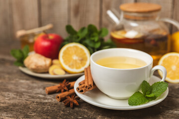 Fragrant hot tea with cinnamon stick and anise on a textured wooden background. A cup of hot tea...