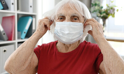 Elderly Woman Puts On Protective Medical Mask On Face