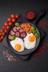 English breakfast with fried eggs, bacon, beans, tomatoes, spices and herbs