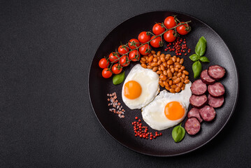 English breakfast with fried eggs, bacon, beans, tomatoes, spices and herbs