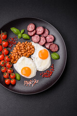 English breakfast with fried eggs, bacon, beans, tomatoes, spices and herbs