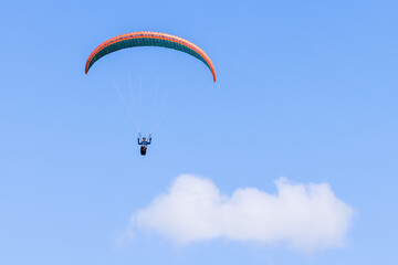 Alone Paraglider flying above the clouds